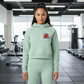 Woman wearing a light green hoodie and leggings set on a white background